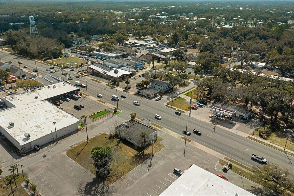 An aerial view shows a commercial street intersection with surrounding buildings, parking lots, and trees — 103 NW US HIGHWAY 19, CRYSTAL RIVER, FL