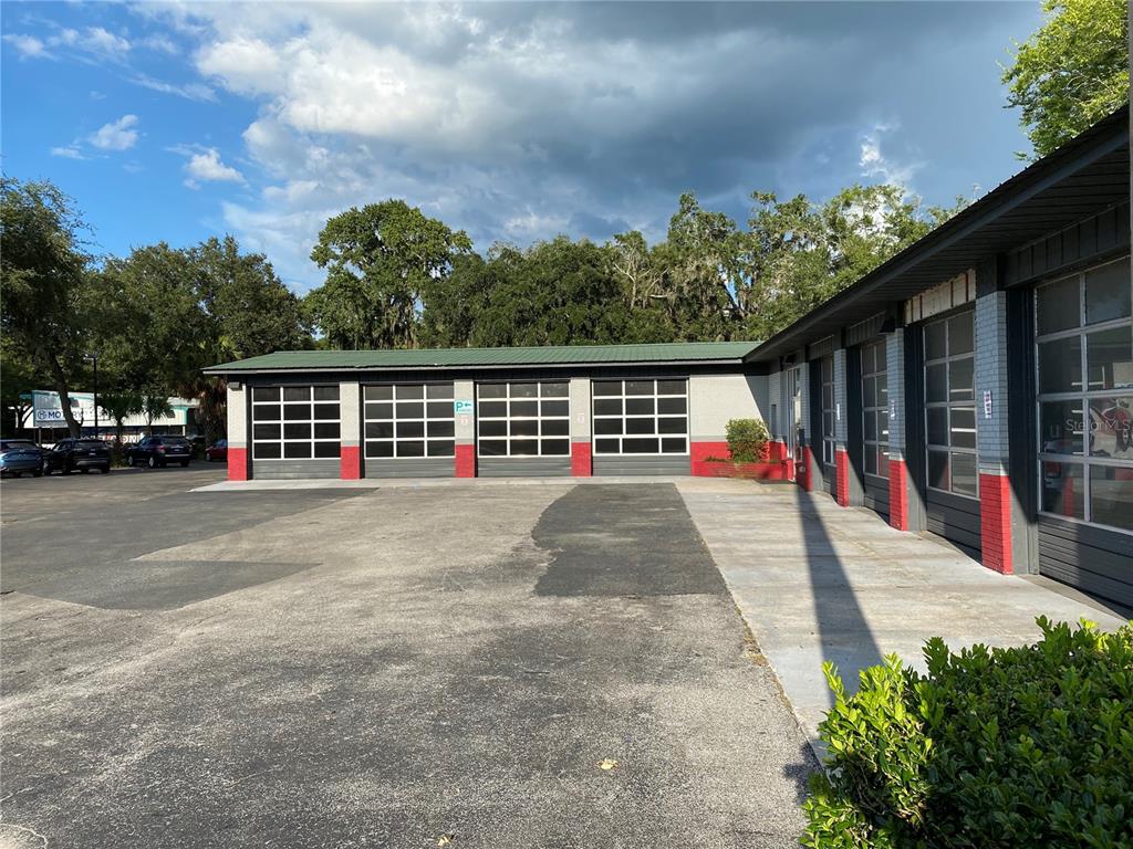 The exterior of a commercial building features multiple garage bays with glass-paneled doors — 2525 N MAIN STREET, GAINESVILLE, FL