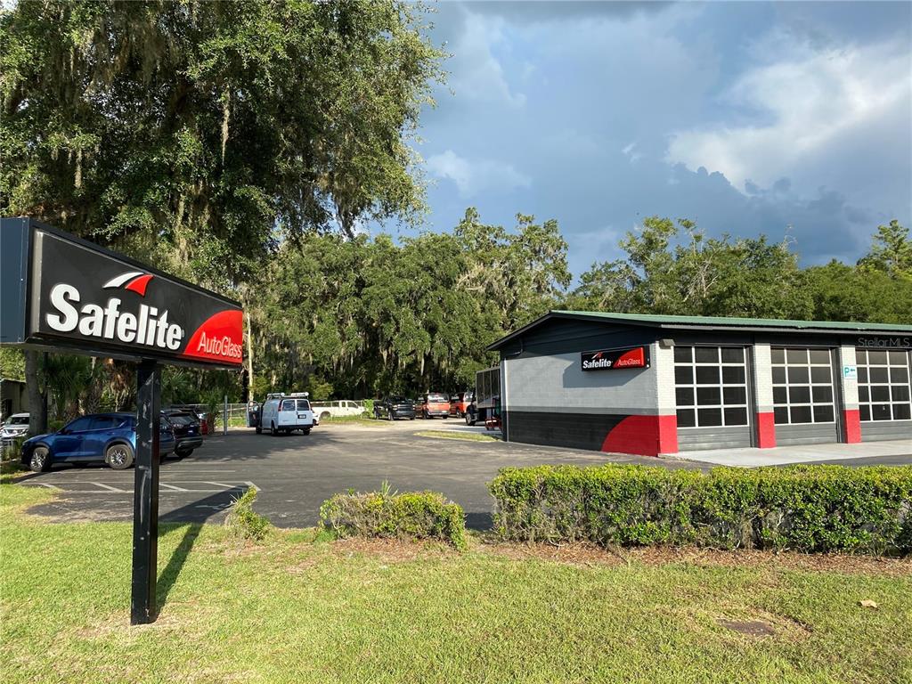 A Safelite AutoGlass service center building with a parking lot and signage — 2525 N MAIN STREET, GAINESVILLE, FL