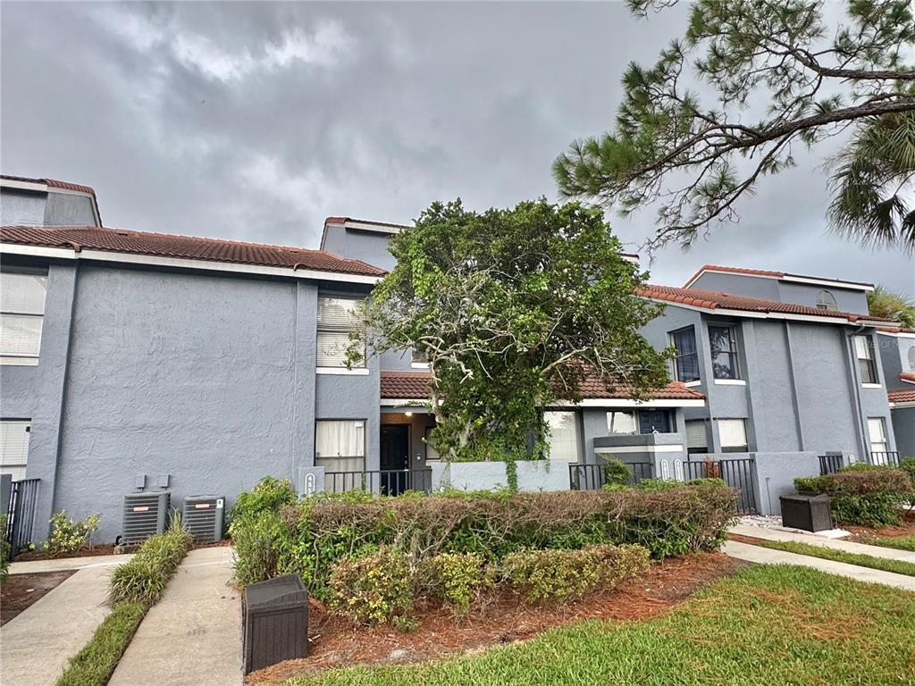 A two-story gray stucco townhouse with a tile roof and a central tree — 4852 MARKS TERRACE UNIT 52, ORLANDO, FL