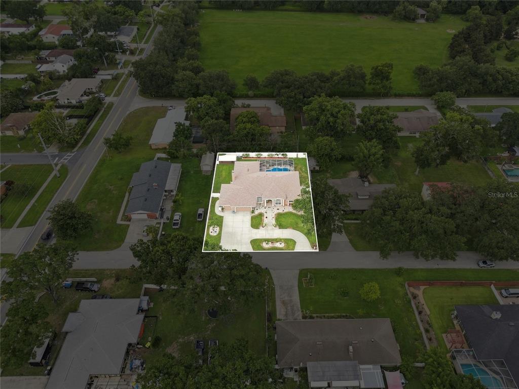An aerial view shows a single-story house with a pool and a large driveway — 5008 LAKEVIEW BOULEVARD, LAKELAND, FL
