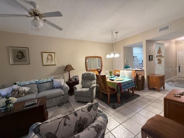 A kitchen features white cabinets, a white refrigerator, a stove, and a small breakfast bar — 4220 CENTRAL SARASOTA PARKWAY UNIT 1215, SARASOTA, FL