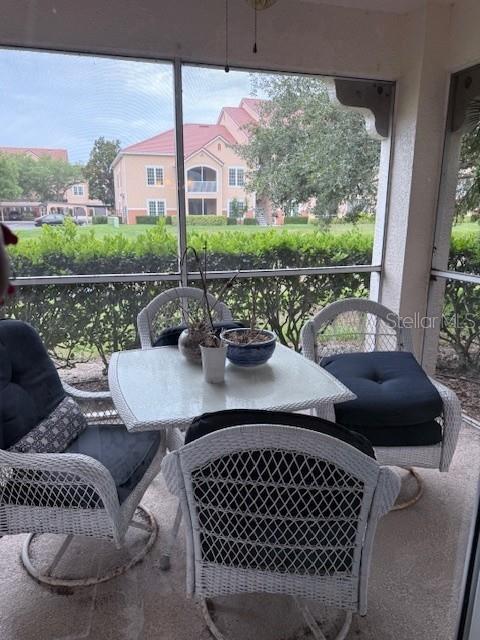 An empty room features light-colored tile flooring, a ceiling fan, and sliding glass patio doors — 4220 CENTRAL SARASOTA PARKWAY UNIT 1215, SARASOTA, FL