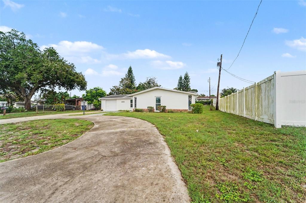 A single-story white house with a concrete driveway and a white vinyl fence — 3536 KIMBERLY OAKS DRIVE, HOLIDAY, FL