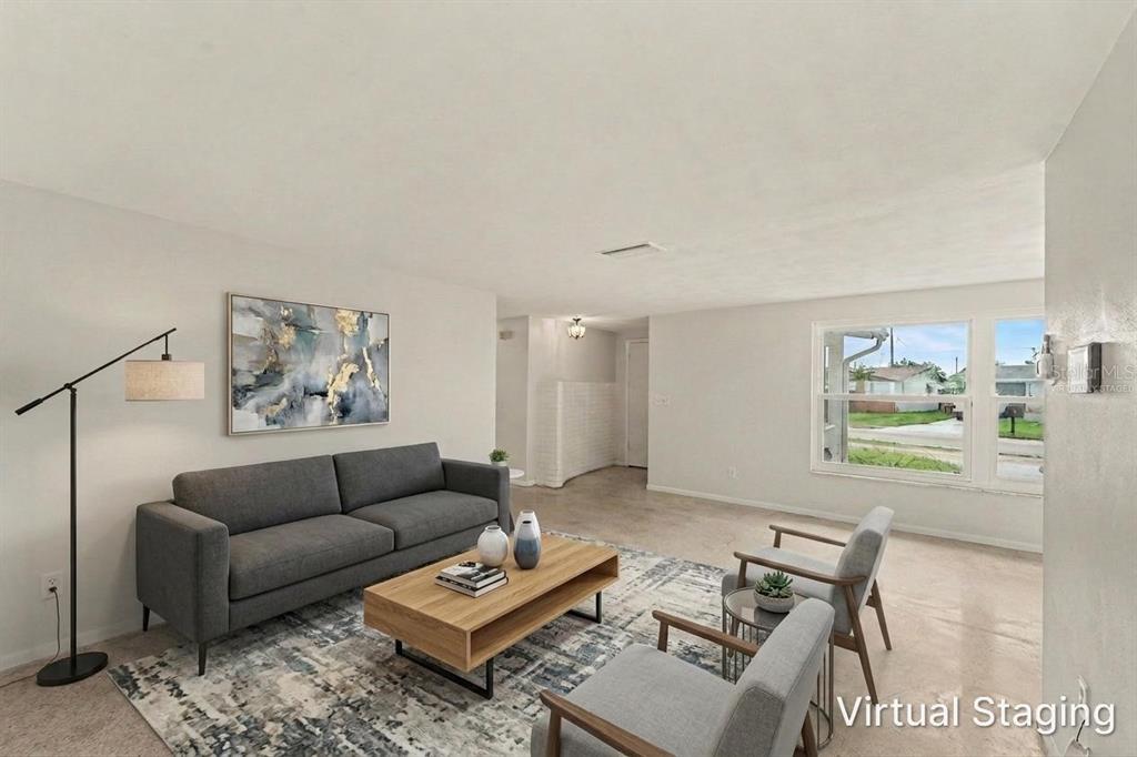 A living room with a gray sofa, two armchairs, a coffee table, and virtual staging — 3536 KIMBERLY OAKS DRIVE, HOLIDAY, FL