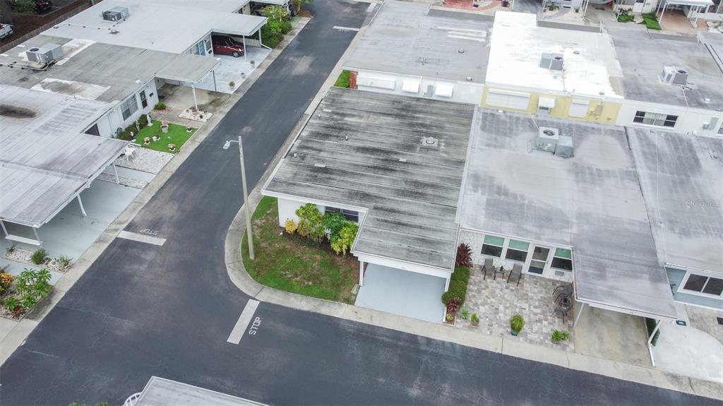 An aerial view shows a flat-roofed house with a carport and a paved patio area — 13940 ANONA HEIGHTS DRIVE UNIT 70, LARGO, FL