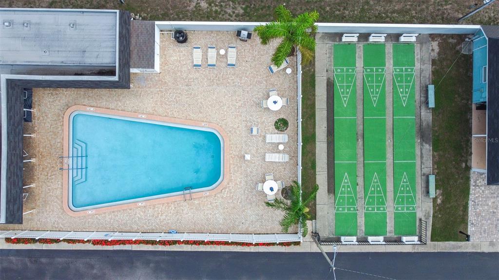 An aerial view shows a swimming pool, patio area, and three shuffleboard courts — 13940 ANONA HEIGHTS DRIVE UNIT 70, LARGO, FL