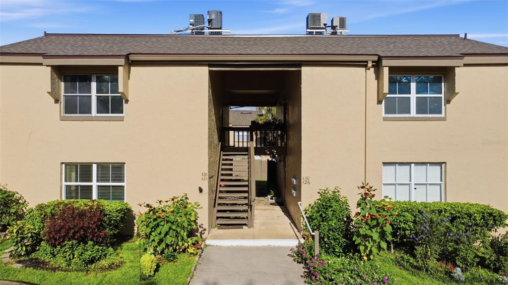 An exterior view of a two-story apartment building with a central staircase and landscaping — 430 WINDMEADOWS STREET, ALTAMONTE SPRINGS, FL