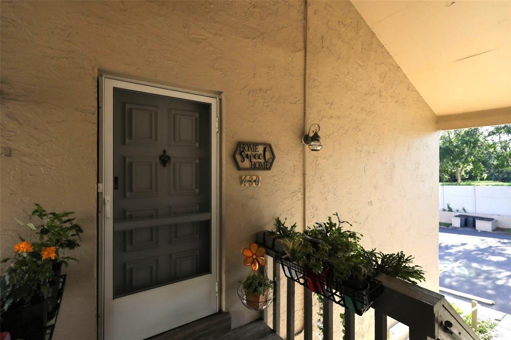 A front porch features a screen door, a decorative sign, and potted plants on a railing — 430 WINDMEADOWS STREET, ALTAMONTE SPRINGS, FL