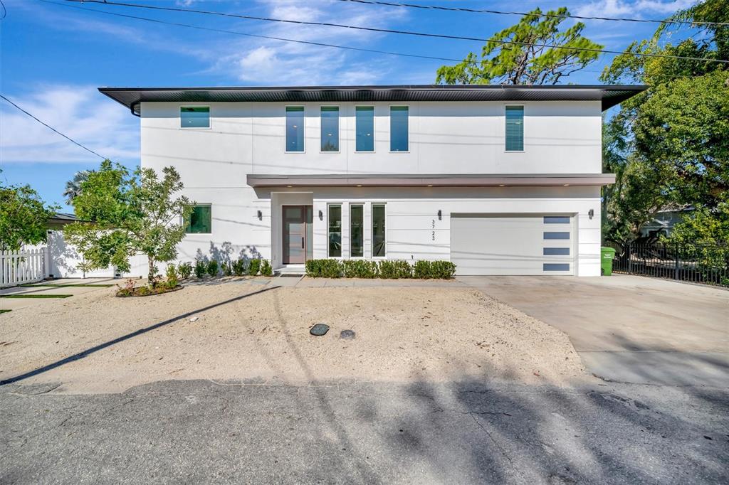 A modern two-story white house features a garage, flat roof, and a gravel front yard — 3723 NORWOOD COURT, SARASOTA, FL