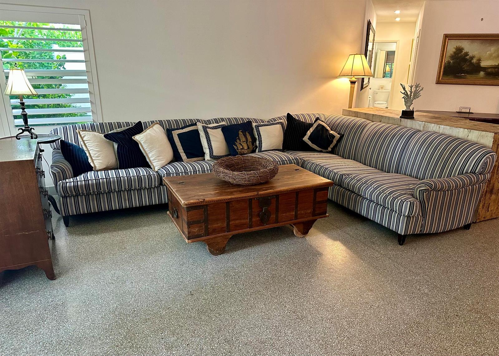 A living room features a striped sectional sofa, a wooden chest coffee table, and terrazzo flooring — 212 Kings Lynn, Delray Beach FL 33444, DELRAY BEACH, FL