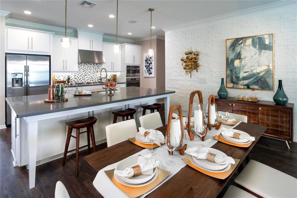A modern kitchen with a large island and dining area featuring white brick walls — 16224 ALPHA GROVE PLACE, ODESSA, FL