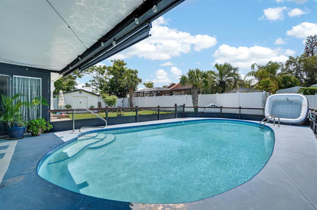 A backyard features a swimming pool, a portable hot tub, and a covered patio area — 792 N BEACH STREET, ORMOND BEACH, FL