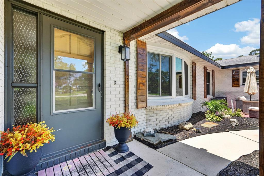 A front entryway features a grey door, white brick walls, and a curved bay window — 792 N BEACH STREET, ORMOND BEACH, FL