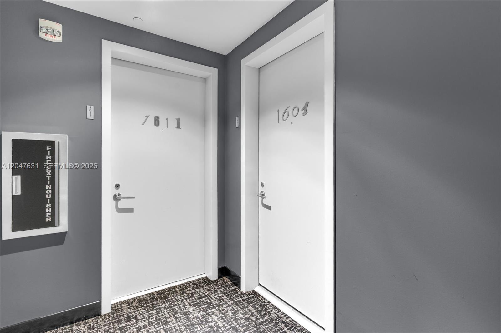 Two white apartment doors with unit numbers are set in a gray hallway with carpet — 1300 S Miami Ave # 1601, Miami FL 33130, MIAMI, FL