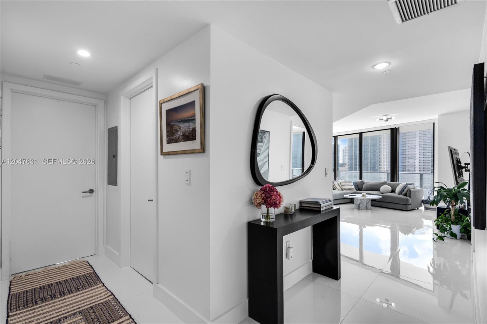 A bright entryway leads into a living room with white tile floors and city views — 1300 S Miami Ave # 1601, Miami FL 33130, MIAMI, FL