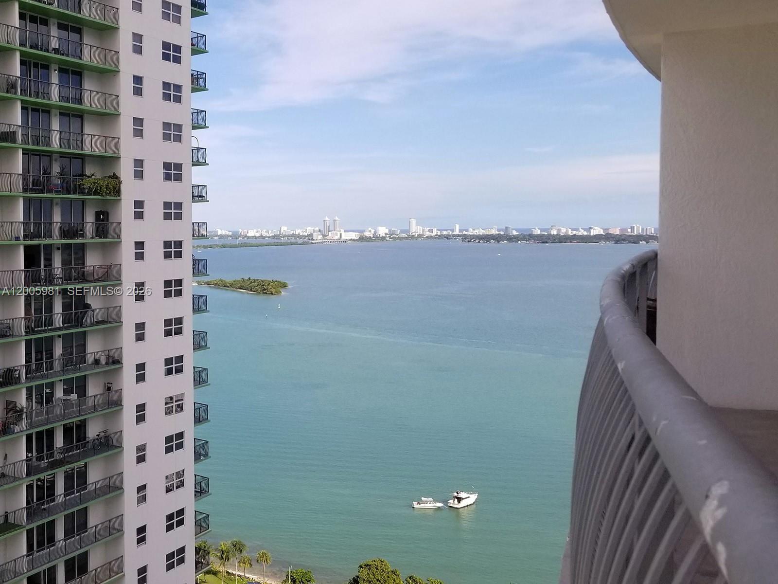 A high-rise balcony view overlooks a bay with boats and a distant city skyline — 1750 N BAYSHORE DR # 2909, Miami FL 33132, MIAMI, FL