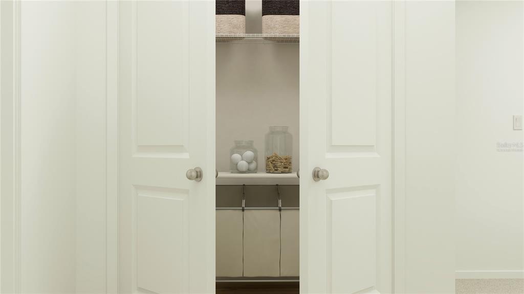 A closet with white double doors, wire shelving, storage bins, and a laundry sorter — 3060 CAPTAIN JAX WAY, WINTER HAVEN, FL