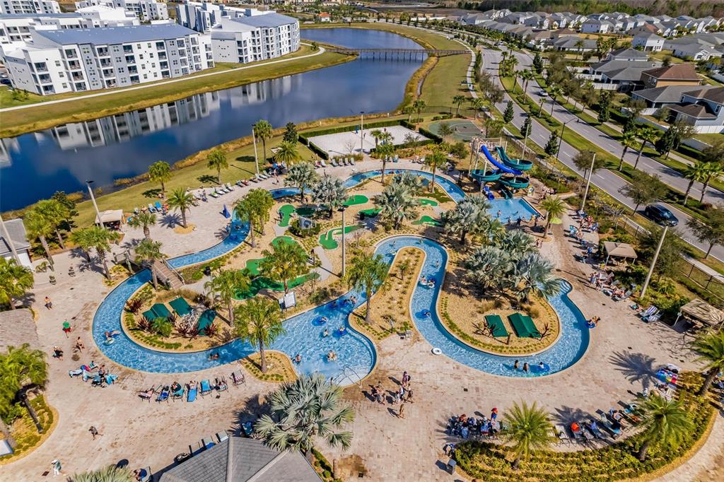 An aerial view shows a resort-style lazy river, swimming pool, water slide, and miniature golf course — 3191 PARADOX CIRCLE UNIT 401, KISSIMMEE, FL