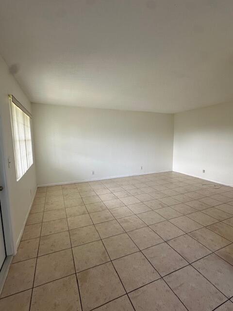 An empty room with beige tile flooring and white walls features a window with blinds — 72 Norwich C, West Palm Beach FL 33417, WEST PALM BEACH, FL