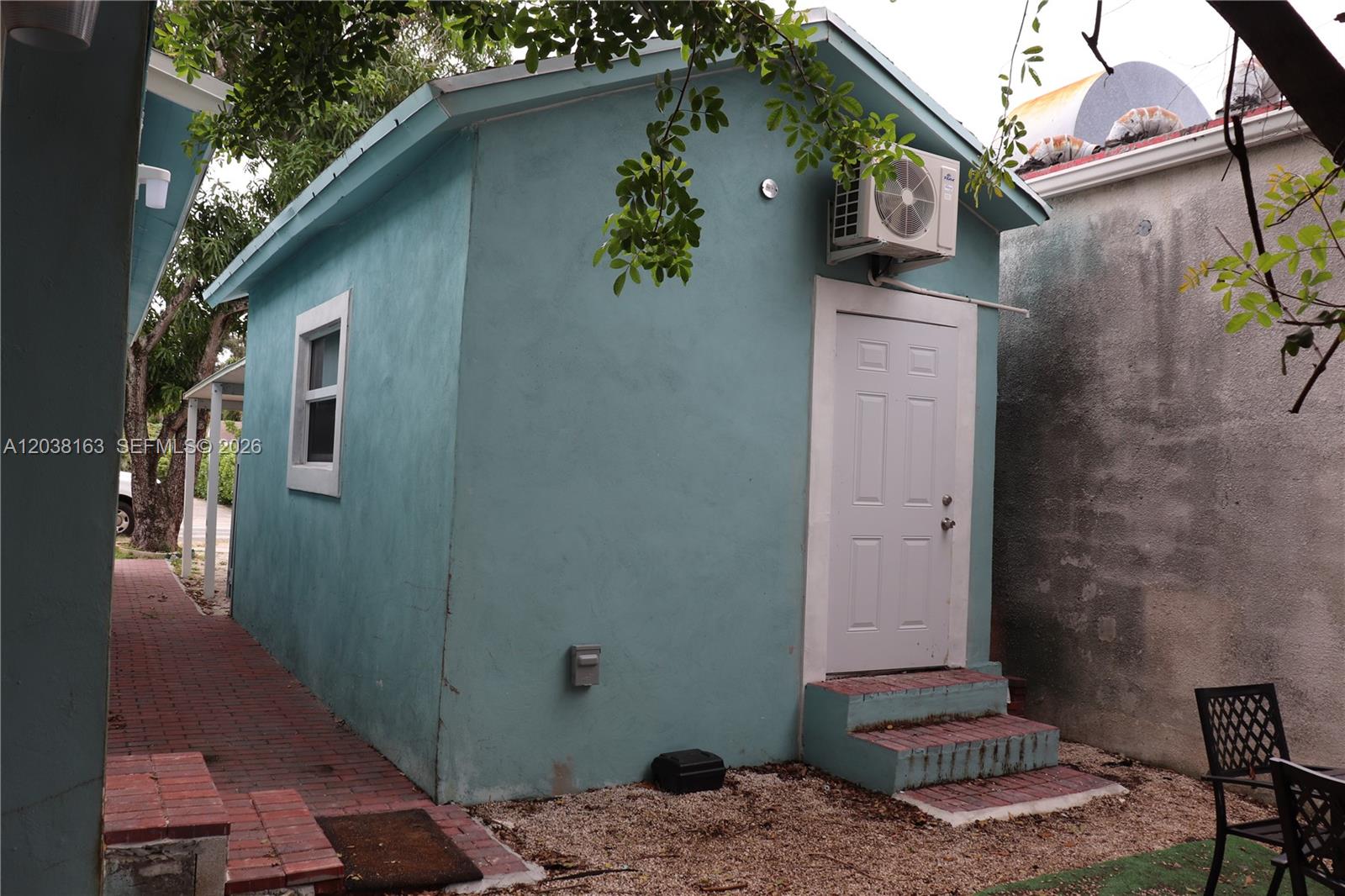 A small, light blue detached structure features a white door, a window, and an air conditioner — 214 SW 2nd Ter, Dania Beach FL 33004, DANIA BEACH, FL