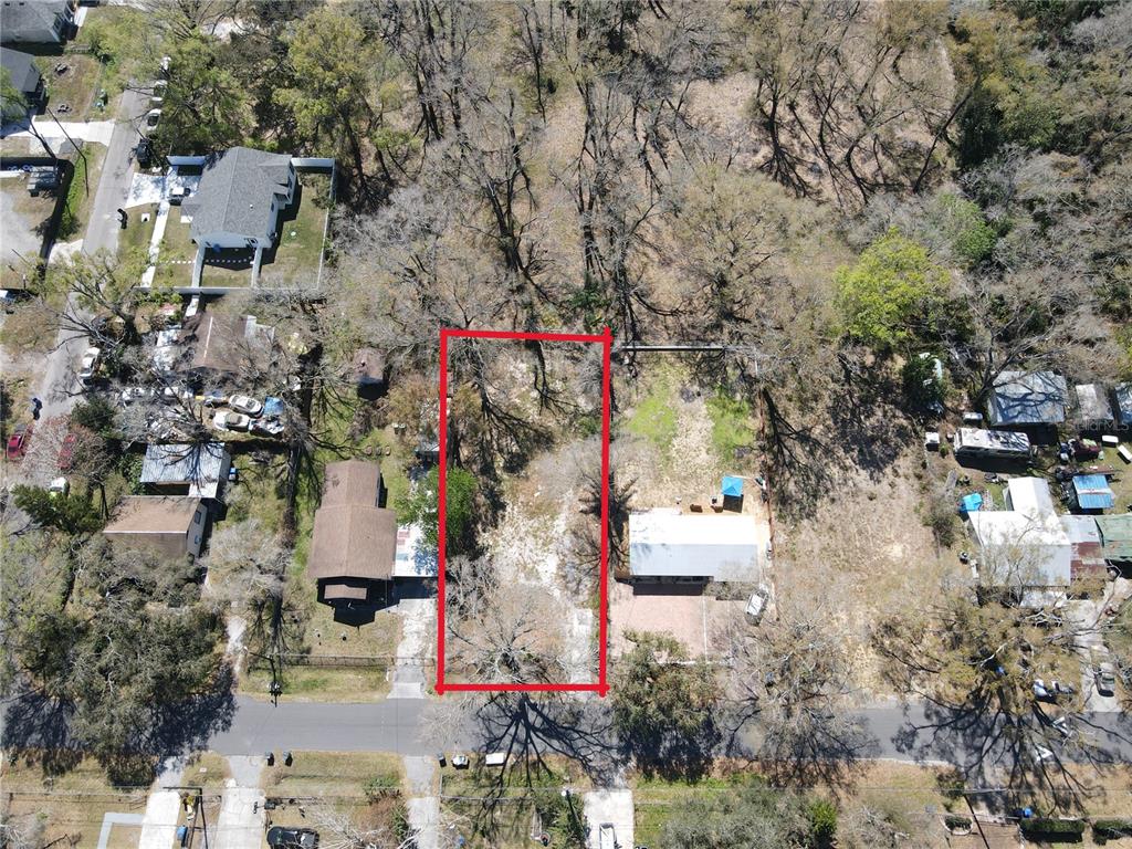 An aerial view shows a rectangular vacant lot outlined in red between two existing houses — 7207 RHODE ISLAND DRIVE, TAMPA, FL