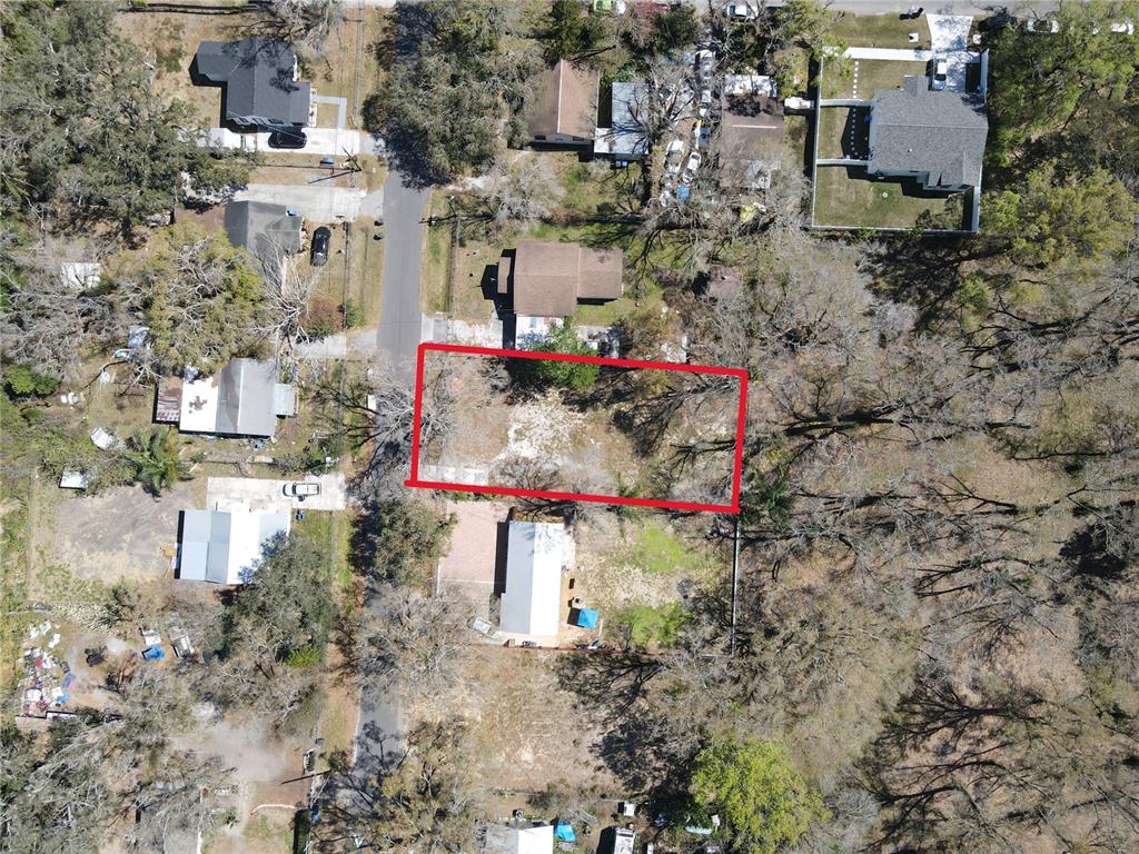An aerial view shows a rectangular vacant lot outlined in red within a residential neighborhood — 7207 RHODE ISLAND DRIVE, TAMPA, FL
