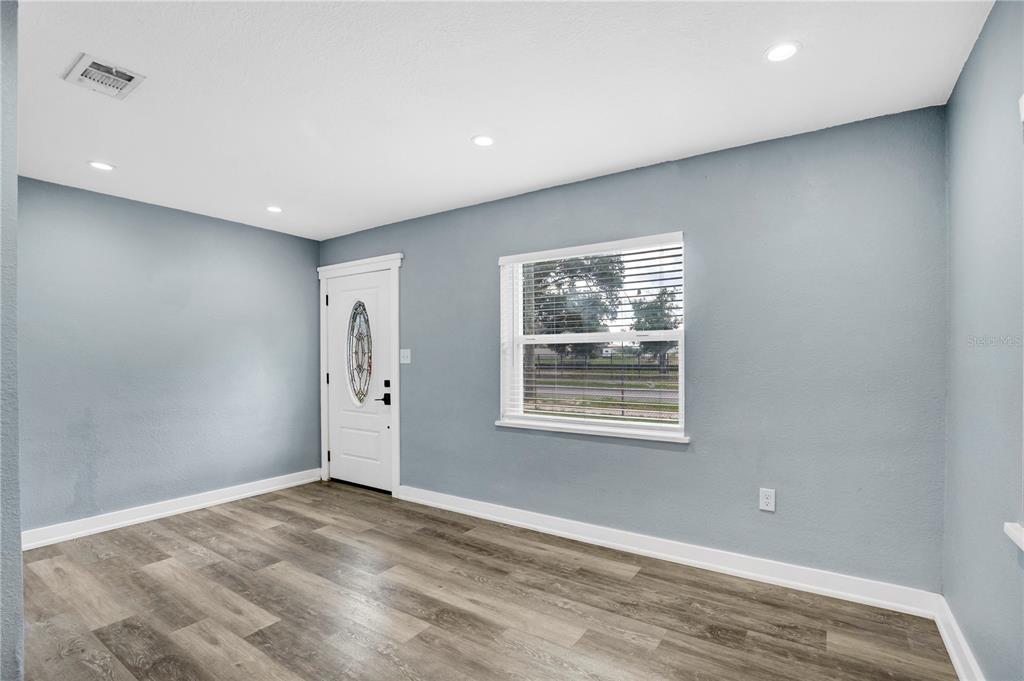 A blue house exterior features a white front door with an oval glass insert — 1113 S CENTRAL AVENUE, LAKELAND, FL