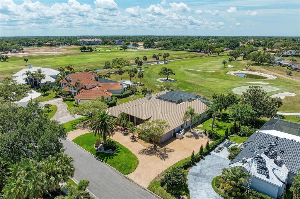 An aerial view shows a residential neighborhood with houses bordering a large golf course — 4268 LAS PALMAS WAY, SARASOTA, FL