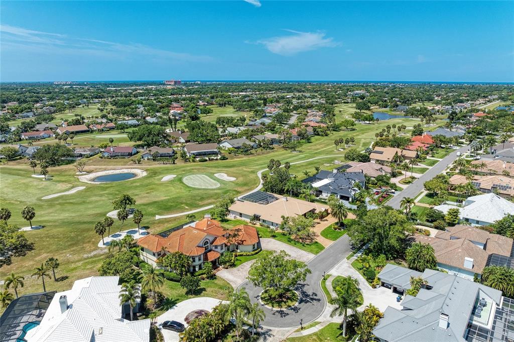 An aerial view shows houses situated along a golf course under a clear blue sky — 4268 LAS PALMAS WAY, SARASOTA, FL