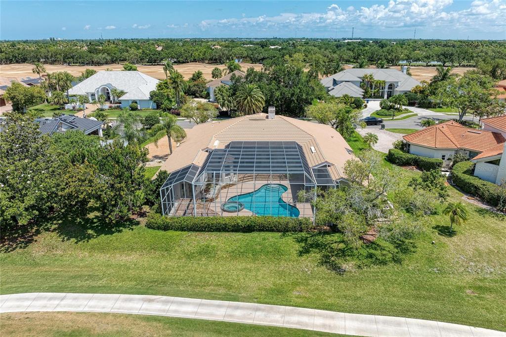 An aerial view of a house with a screened-in pool and a tan tile roof — 4268 LAS PALMAS WAY, SARASOTA, FL