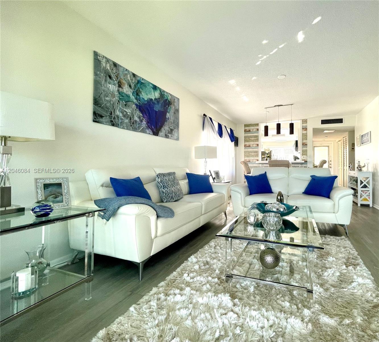 A living room features white leather sofas, a glass coffee table, and a shag rug — 5980 NW 64th Ave # 312, Tamarac FL 33319, TAMARAC, FL