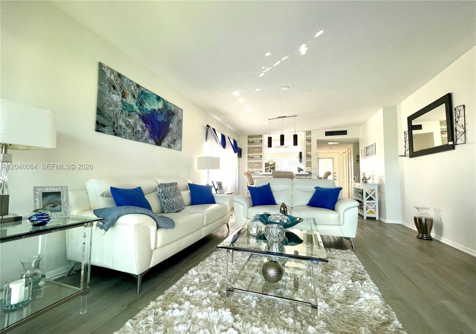 A living room features two white sofas, a glass coffee table, and a shag rug — 5980 NW 64th Ave # 312, Tamarac FL 33319, TAMARAC, FL