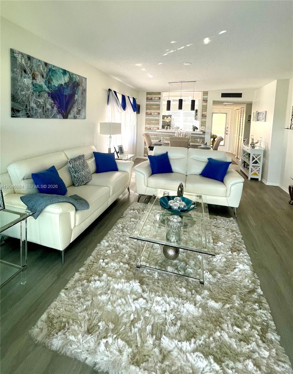 A living room features two white leather sofas, a glass coffee table, and a shag rug — 5980 NW 64th Ave # 312, Tamarac FL 33319, TAMARAC, FL