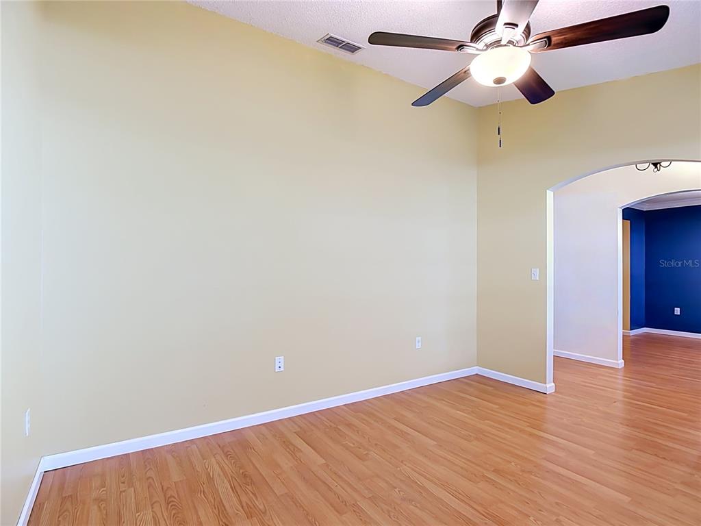 A room with light yellow walls, hardwood flooring, and a ceiling fan — 166 BUCKHORN RUN, LAKELAND, FL