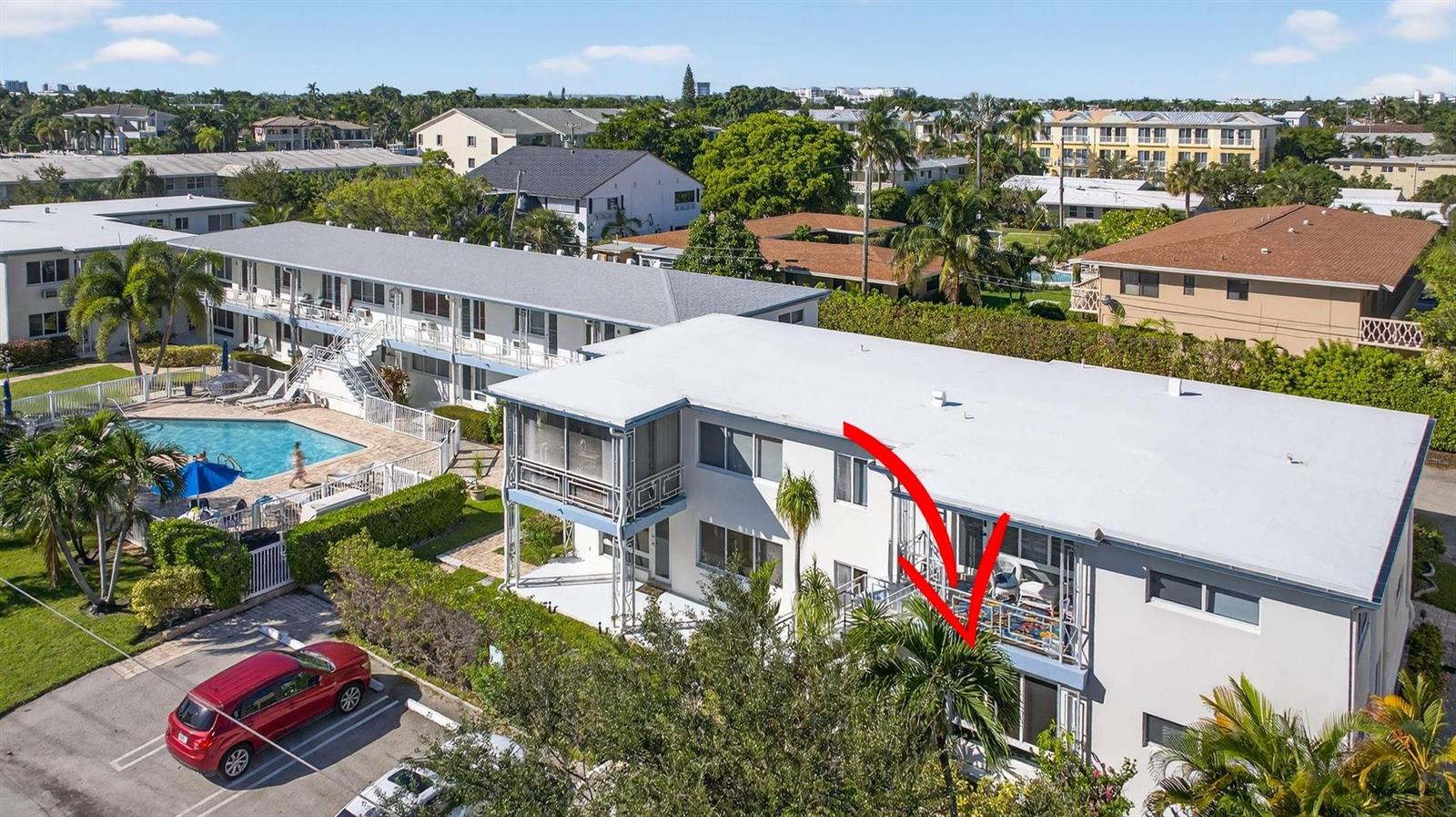An aerial view of a multi-story apartment building with a red arrow pointing to a balcony — 3201 SE 12th Street # C2, Pompano Beach FL 33062, POMPANO BEACH, FL