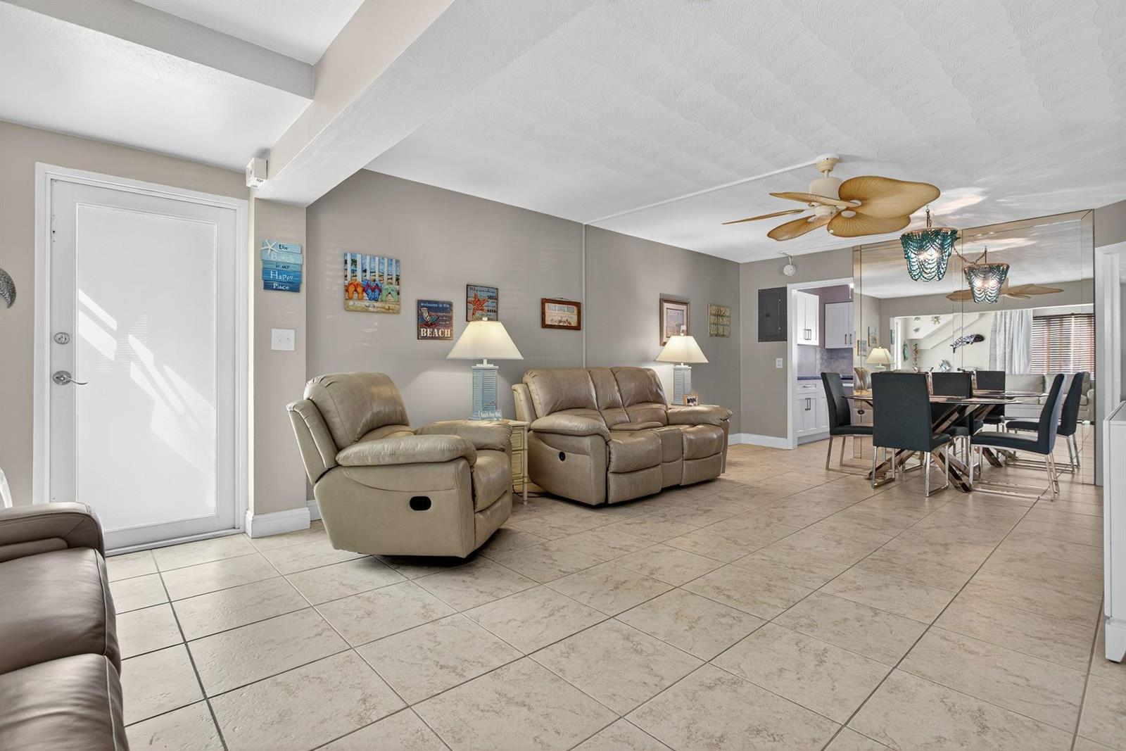 A living room with beige tile floors, a recliner, a loveseat, and a dining area — 3201 SE 12th Street # C2, Pompano Beach FL 33062, POMPANO BEACH, FL