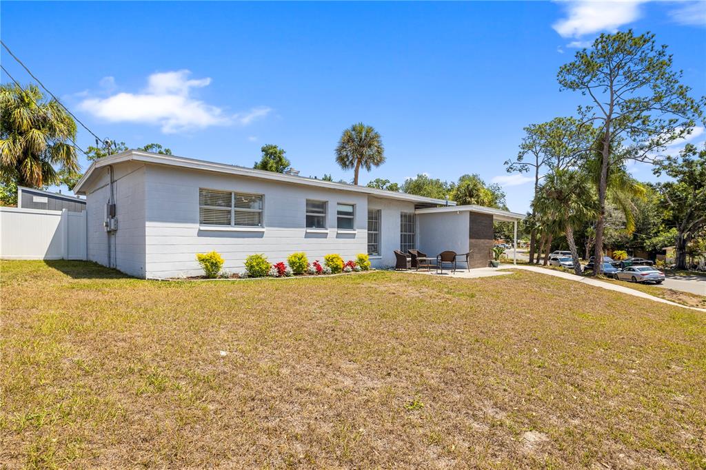 A single-story house with a light gray exterior, a small patio, and a grassy yard — 2125 W HIAWATHA STREET, TAMPA, FL