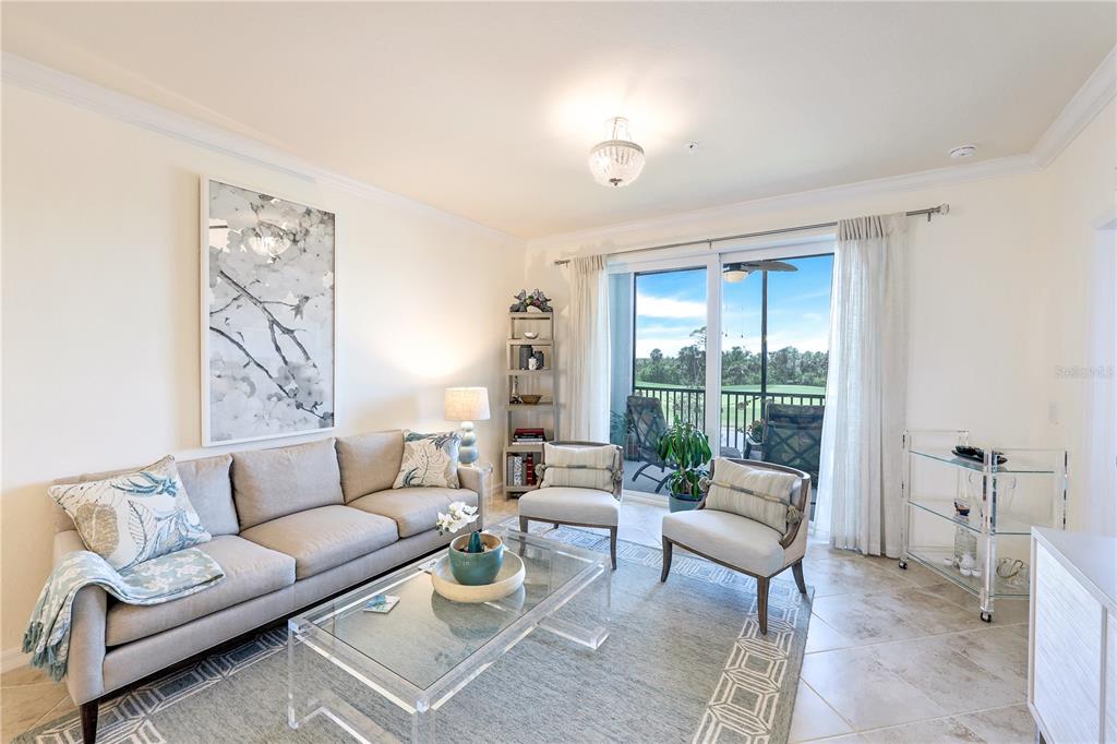 A living room features a beige sofa, two armchairs, a glass coffee table, and sliding doors — 14051 HERITAGE LANDING BOULEVARD UNIT 524, PUNTA GORDA, FL