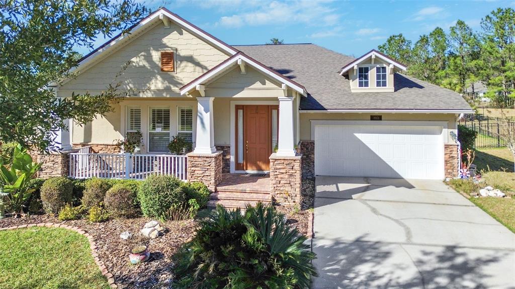 A single-story house with a stone-accented facade, a front porch, and an attached two-car garage — 19531 MOSSY OAK COURT, BROOKSVILLE, FL
