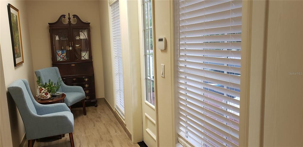 A room features two light blue armchairs, a dark wood hutch, and windows with white blinds — 16013 N FLORIDA AVENUE, LUTZ, FL
