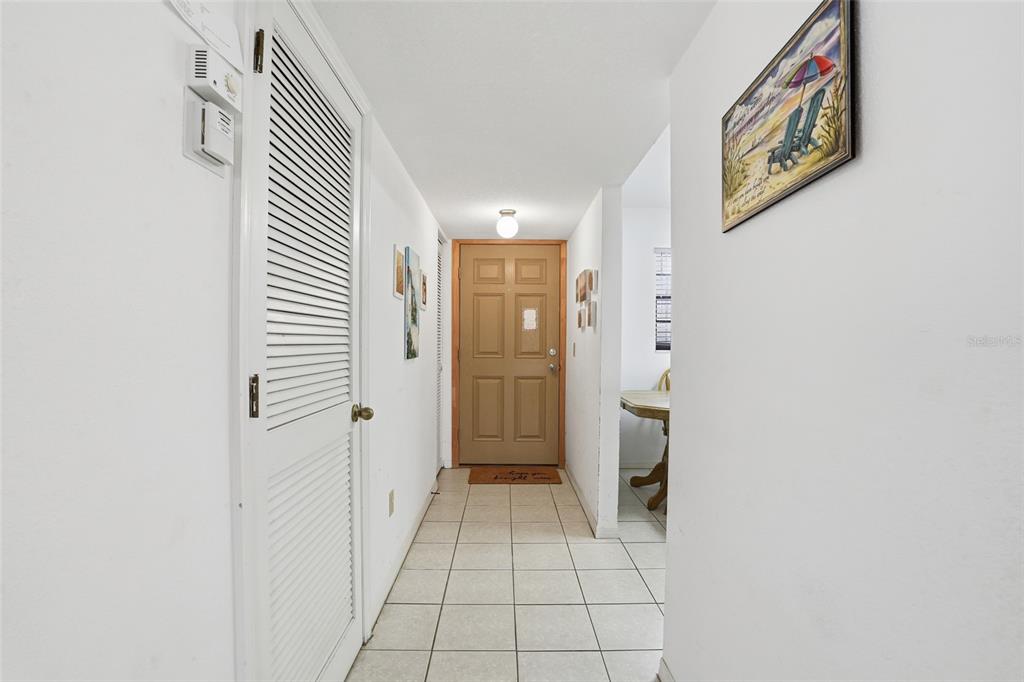 A tiled entryway features a louvered closet door, a tan front door, and white walls — 175 KINGS HIGHWAY UNIT 635, PUNTA GORDA, FL