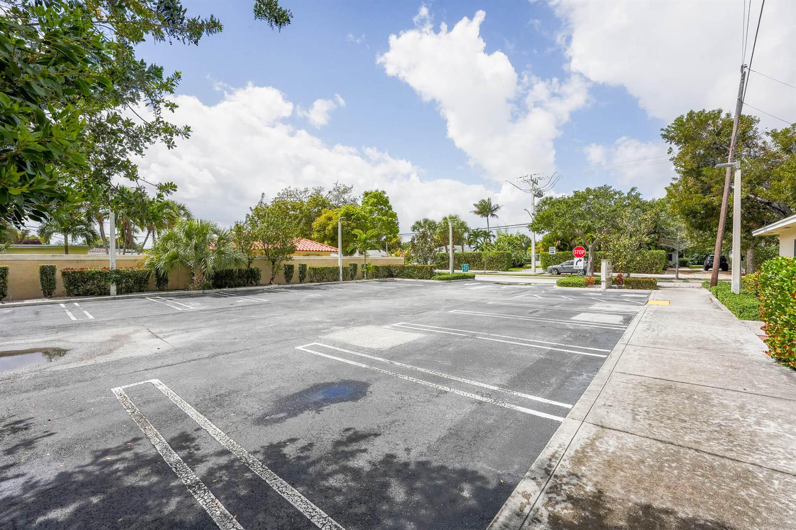 An empty asphalt parking lot features marked spaces, surrounding landscaping, and a stop sign — 912 SE 4th Street, Boynton Beach FL 33435, BOYNTON BEACH, FL