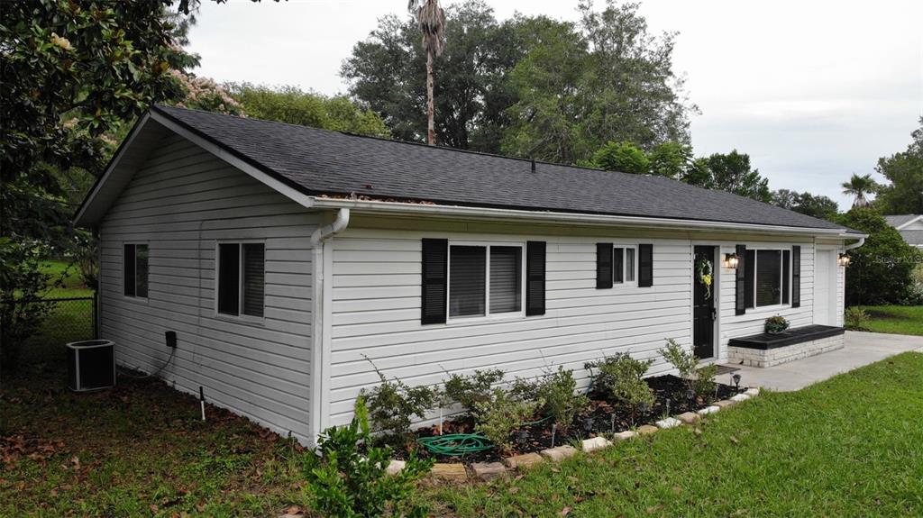 A white, single-story house with black shutters and a dark shingled roof — 10740 SW 62ND AVENUE ROAD, OCALA, FL