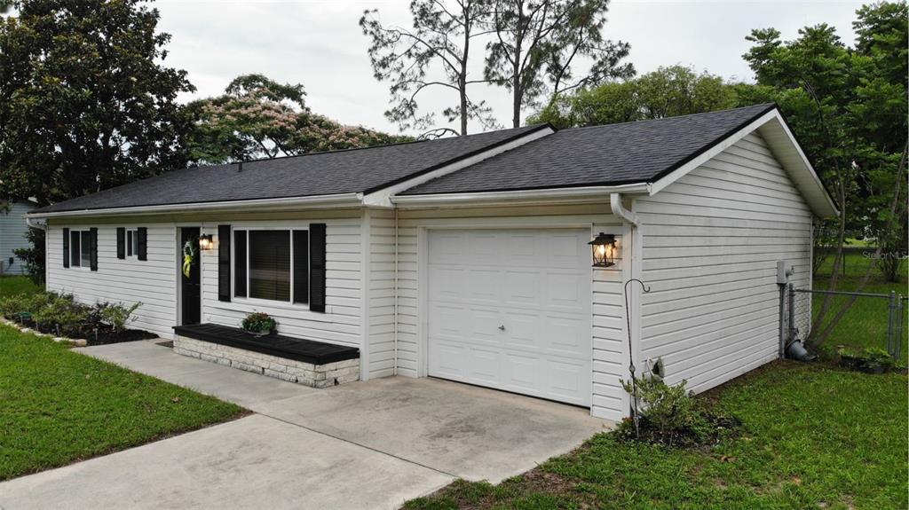 A single-story house with white horizontal siding, a dark shingled roof, and an attached garage — 10740 SW 62ND AVENUE ROAD, OCALA, FL