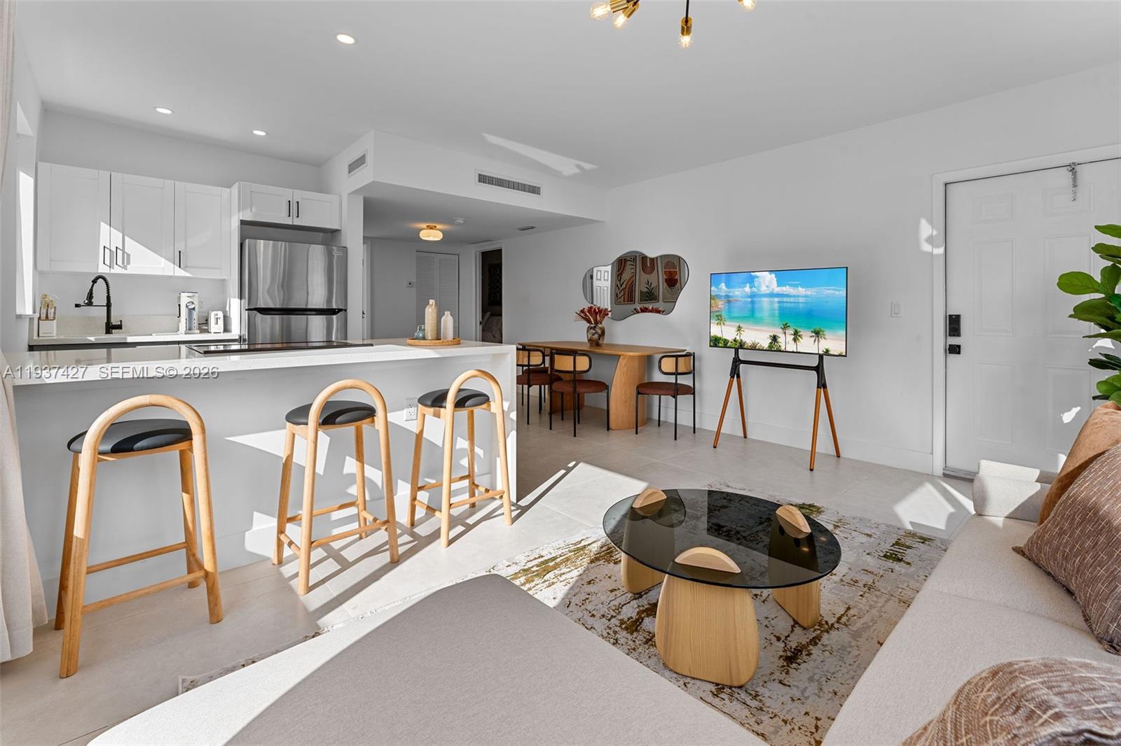A bright, open-concept living and dining area features a modern kitchen with white cabinetry — 1144 SW 4th St # 8, Miami FL 33130, MIAMI, FL
