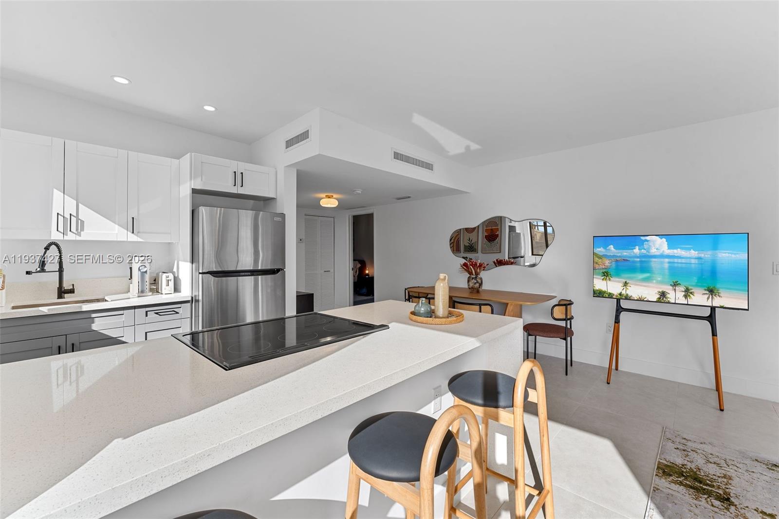 A modern kitchen features white cabinets, stainless steel appliances, and a central island with stools — 1144 SW 4th St # 8, Miami FL 33130, MIAMI, FL