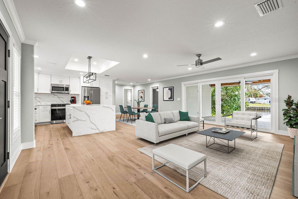 An open-concept living area features a kitchen with a marble island and sliding glass doors — 170 98TH AVENUE N, ST PETERSBURG, FL