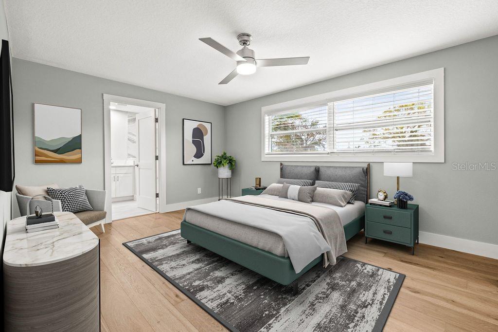A bedroom features a teal bed frame, a patterned area rug, and light wood flooring — 170 98TH AVENUE N, ST PETERSBURG, FL