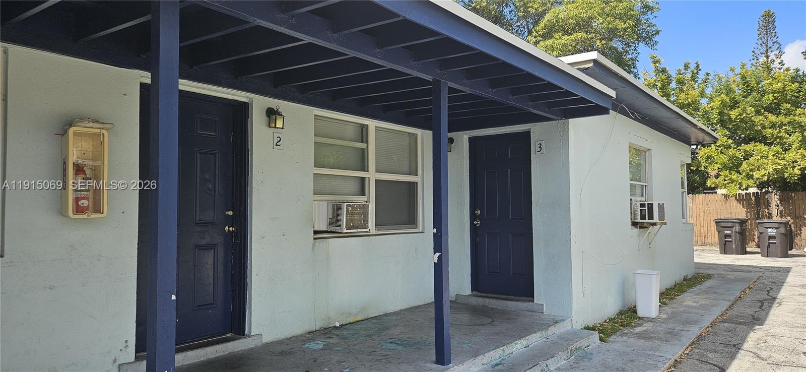 The exterior of a single-story building features two blue doors labeled 2 and 3 — 817 Grant St, West Palm Beach FL 33407, WEST PALM BEACH, FL